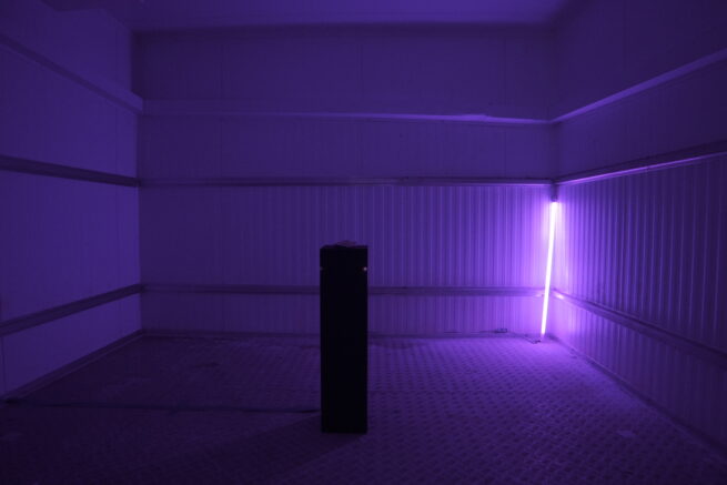 the art installation. It is composed by a plinth that has a small clay sculpture on top. Back of the plinth is a lamp that dims down when the visitor approaches the plinth