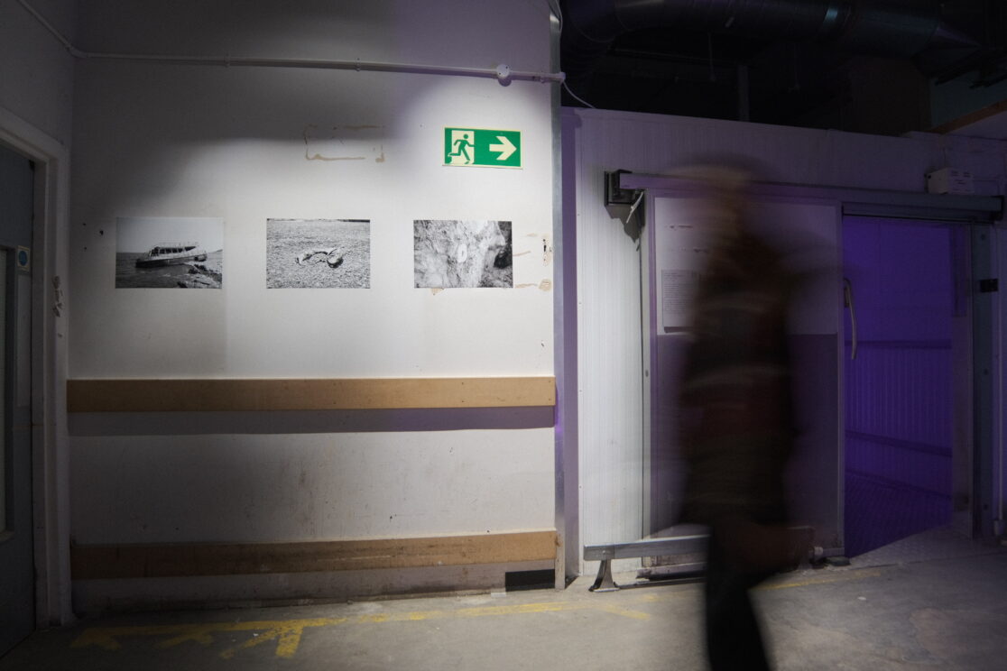 Outside space of the installation look for yourself or a human rights graveyard. Three photos in black and white are visible. First photo shows a sunk boat in lesvos island, the second photo shows evidences of a destroyed plastic boats in a beach in lesvos and the third photo shows the artist's sculpture that it is casted in the rocks of eftalou beach in lesvos