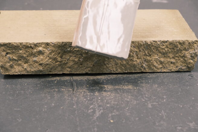 detail of the installation "Human Fragments". In the detail, we see a tile and a brick hit together