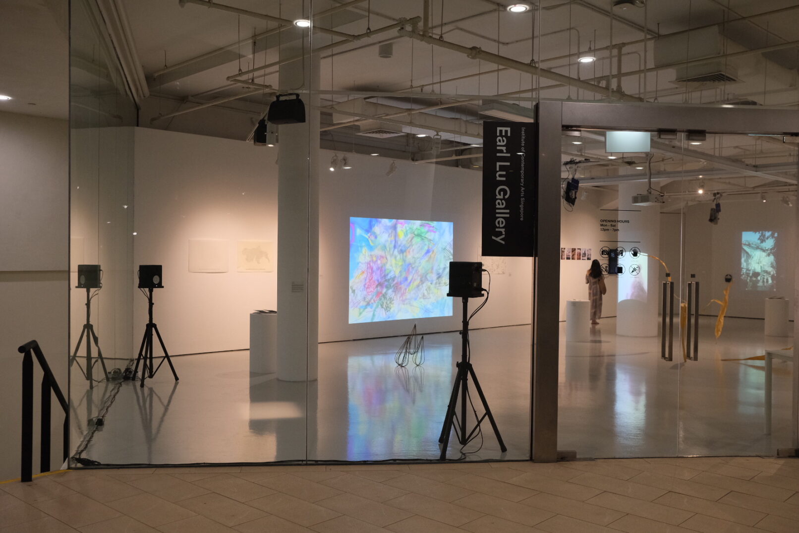 gallery with glass window showing 2 speakers on stands and 2 ceiling speakers