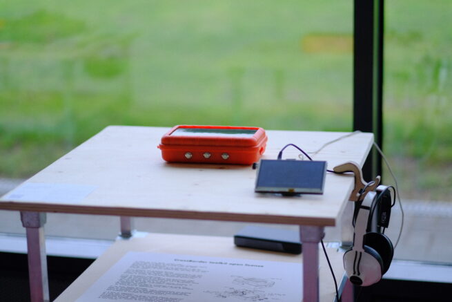 a table with a orange solar device and a small screen